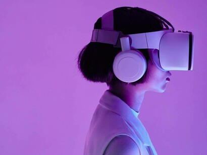 A woman wearing virtual reality goggles and how AI has impacted the gaming industry