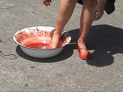 Caminando a paso mesurado durante sesenta minutos con una palangana. Cuando se detiene, sumerge los pies en el contenedor para dejar las huellas de su paso en el camino como huellas aún frescas de un drama ocurrido