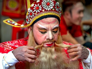 An opera actor making the final touches to his elaborate costume, reflecting the dreams Vương once held before hardship altered his path
