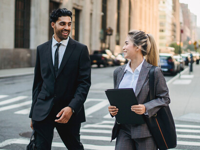 A husband and wife walking confidently toward their next destination, symbolising a partnership built on shared ambition and mutual encouragement