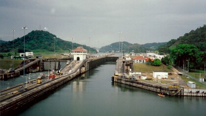 The imposing locks and serene waters of the Panama Canal stretch towards the horizon, a marvel of engineering that connects the Atlantic and Pacific Ocean and a crucial link in global maritime trade