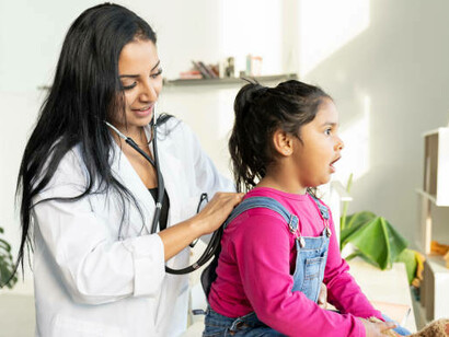 In the Global South, a Latin American woman undergoes a medical exam at home, benefiting from local community health and nutrition programs