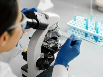 A woman meticulously scrutinizing samples under a powerful microscope, delving deep into the intricacies of molecular biology, and venturing into the frontiers of gene therapy and advanced cell-based treatments