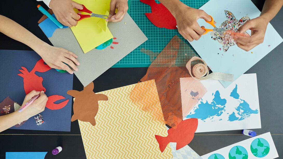 A group of people using scissors and pens to create handmade crafts out of paper