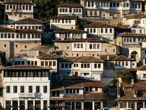 Traditional hillside homes with their distinctive rows of windows and red-tiled roofs, symbolizing why Berat, Albania, is known for its remarkable architecture