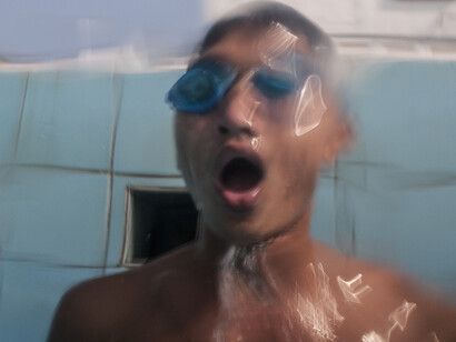 UXO salvage diver Piseth Dara (24) emerges from underwater in
the Olympic swimming pool
in Phnom Penh,Cambodia. Prior to the diver training the majority
of the team had basic swimming skills, now they are all strong
swimmers due to the intense nature of the training required to be a
salvage diver