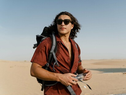 A traveler staying hydrated with a reusable water bottle, symbolizing mindful choices that help protect the environment