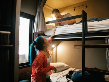 New friends connecting inside a hostel dorm, symbolising how shared spaces give rise to meaningful conversations