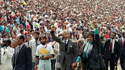 Nelson and Winnie Mandela hold their fists to the sky as ANC supporters cheer on during a rally at the FNB Stadium in Soweto, Johannesburg, held on the 16th of December, 1990, shortly after Nelson Mandela's release from prison