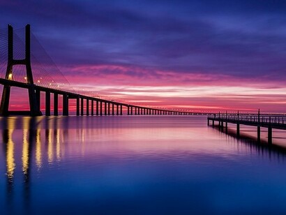 Pôr do sol na Ponte Vasco da Gama sobre o estuário do rio Tejo, Lisboa, Portugal