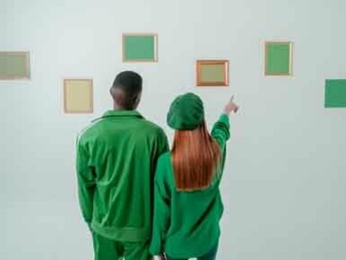 Coppia vestita di verde in ammirazione di opere d'arte