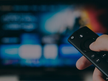 An individual grasping a black remote control