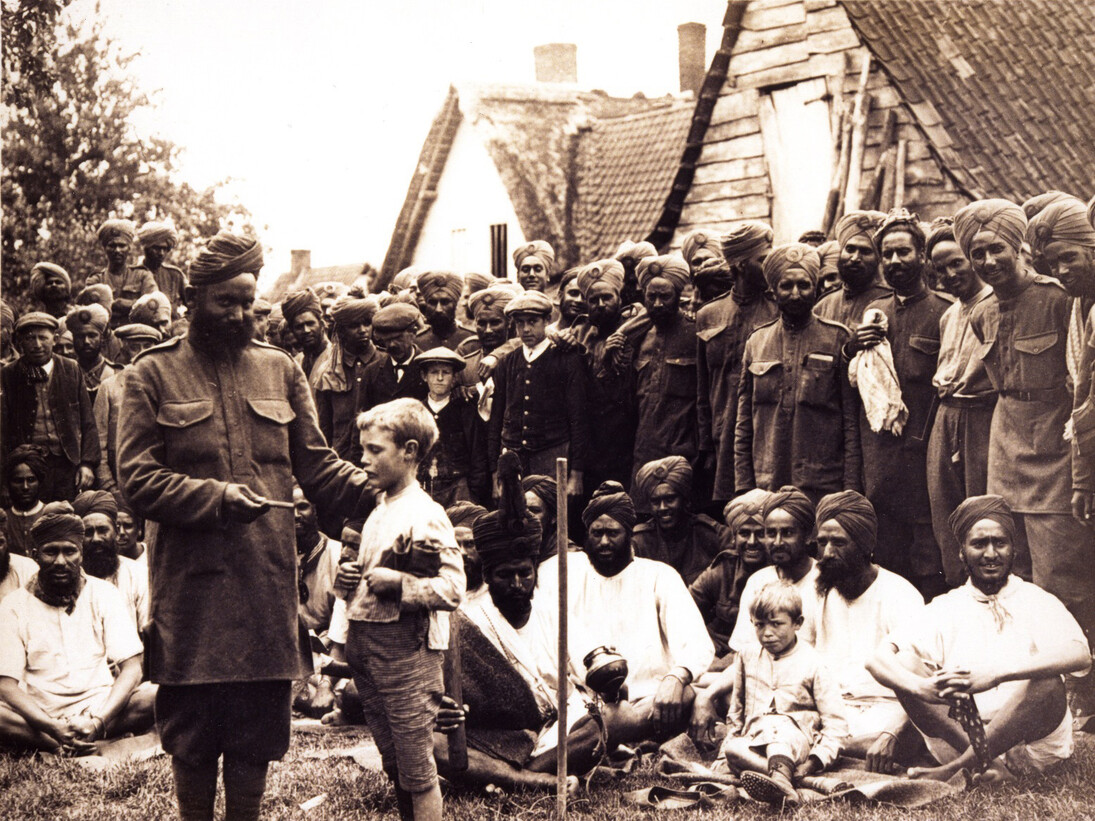 Men of the 15th Sikh Regiment spend time with the locals in a Flanders village after weeks in the trenches of the Western Front, c. 1915. (Source: UKPHA Archive)