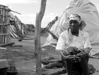 Mujer mozambicana descansa fuera de su vivienda