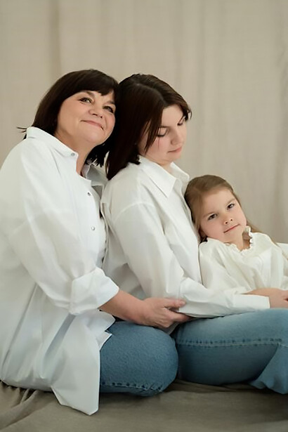 Capturing a timeless essence, a grandmother, daughter, and granddaughter strike a pose together, their shared features embodying the continuity of human nature through the generations. In this brief moment, the photograph radiates the enduring significance of family ties