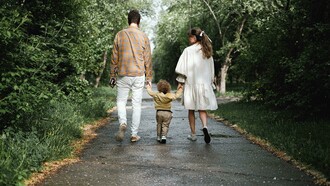 A couple walking in the park with their child