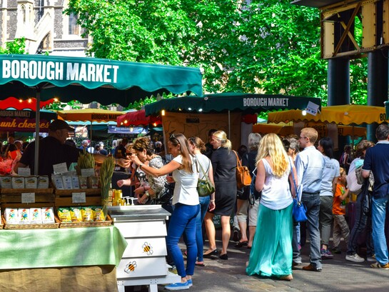 Local vendors welcoming visitors at Borough Market in London, presenting the city's commitment to preserving its culinary traditions