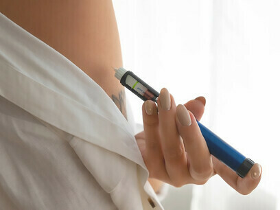 Seitenansicht einer Diabetes-Patientin, die ihren Blutzuckerspiegel überprüft