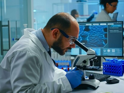 A scientist investigating biological structures while reviewing digital data, reflecting AI-enhanced scientific decision-making