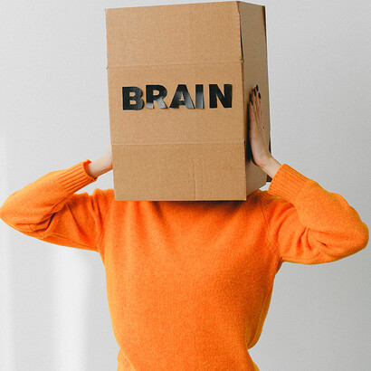 Pessoa com uma caixa na cabeça escrito "brain". Pensar positivo é mais do que uma força do querer
