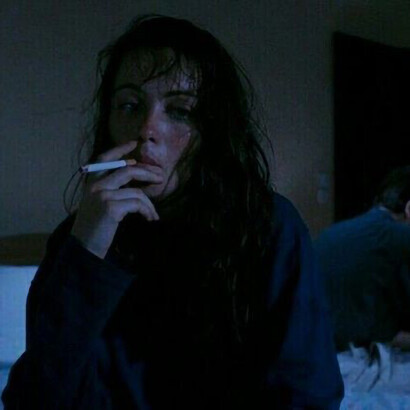 Tears cascade down a woman's face as she takes solace in a cigarette, seeking refuge from her sorrow