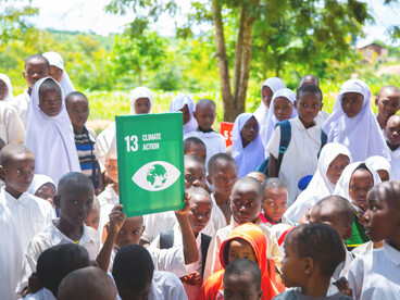 Children actively engaging in outdoor climate advocacy within a rural sustainable development project