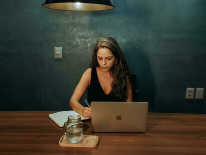 A woman at a table using her laptop, highlighting modern digital engagement