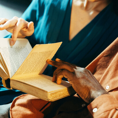 Dos personas hojean cuidadosamente un libro