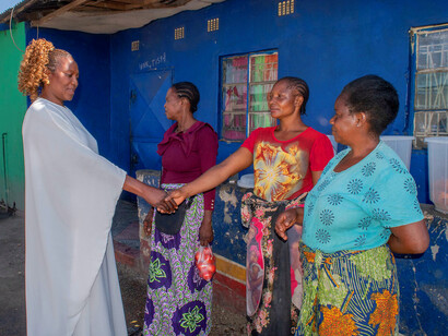 A local leader engages in a heartfelt conversation with the women of the village, embodying the power of collaboration and community amidst global challenges
