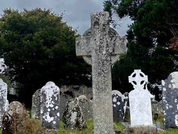 La famosa Torre Redonda de piedra domina el paisaje del antiguo cementerio monástico. Glendalough, Irlanda
