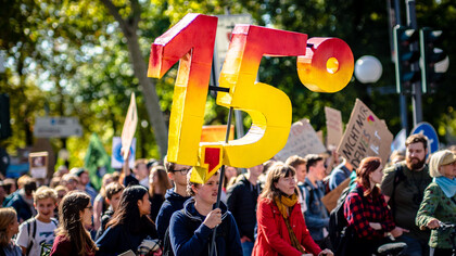 A man holding a 1.5 degrees celsius sign