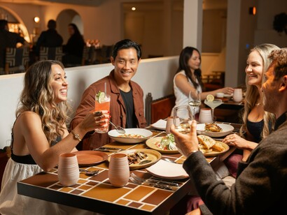 Laughter and locally inspired dishes fill the air as friends gather for a nourishing meal © Photo by Bri Amato