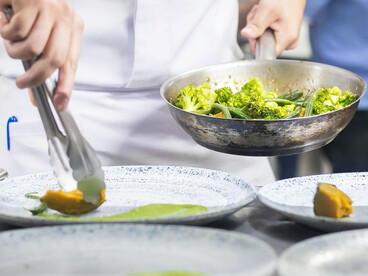 A chef prepares dishes during busy service in the kitchen of a high-end restaurant in São Paulo, Brazil