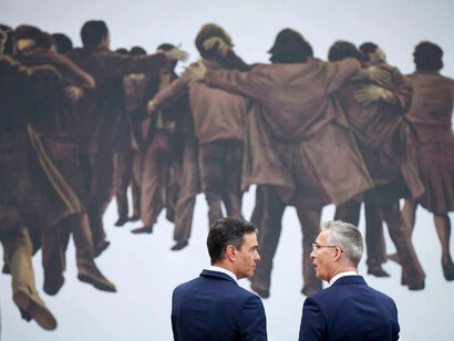 Pedro Sánchez y Jens Stoltenberg frente al cuadro «El abrazo» de 1976, homenaje a los abogados laboralistas asesinados en Atocha por miembros de la extrema derecha, suceso que marcó el tránsito hacia la democracia en España