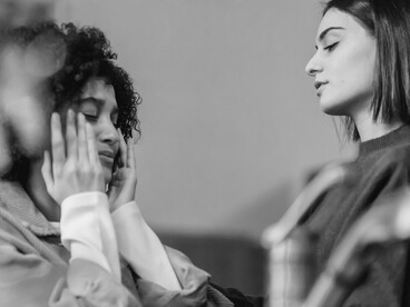 Duas mulheres conversam em um ambiente doméstico, enquanto uma delas oferece apoio e atenção à outra. Saber ouvir pode ser mais valioso do que encontrar a resposta perfeita