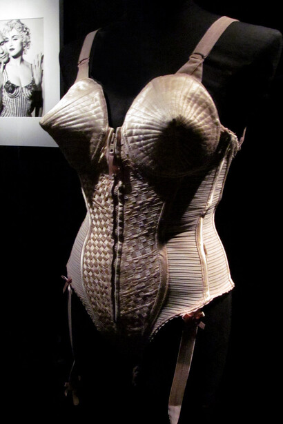 The iconic corset designed by Jean Paul Gaultier, famously worn by Madonna during her 1990 Blond Ambition World Tour, became a symbol of bold fashion and reinvention