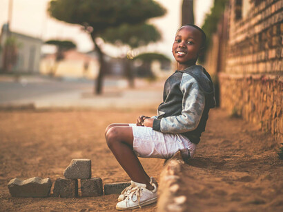 Niño sonríe mientras espera a sus amigos en Maputo, Mozambique