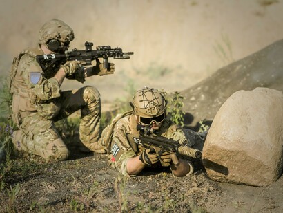 Two soldiers in army uniforms with guns 
