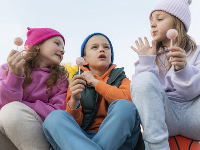 Tres pequeños disfrutan su día juntos, comiendo dulces tras escapar de la escuela