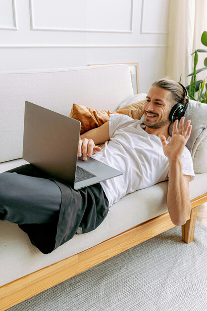 During an online conversation, a man gestures a heart sign with his hands, reflecting emotional connection across a long-distance relationship