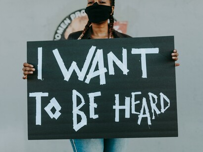 A woman holding a protesting sign that reads: I want to be heard