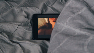 A mobile phone concealed beneath the bedsheets