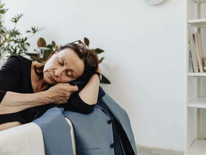 A woman sleeping on the blazer of her lost loved one grieving quietly