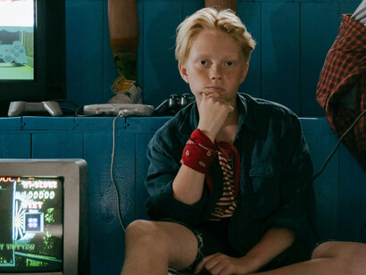 Teenagers seated by an old television, enjoying classic retro games surrounded by vintage game design