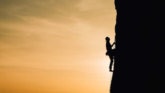 Scaling life's peaks metaphorically, the arduous climb reflects the challenges of achieving success and wealth, mirroring the uphill struggle toward prosperity