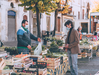 Hombre compra verduras a un comerciante en un mercado al aire libre en Sulmona, Provincia de L'Aquila, Italia