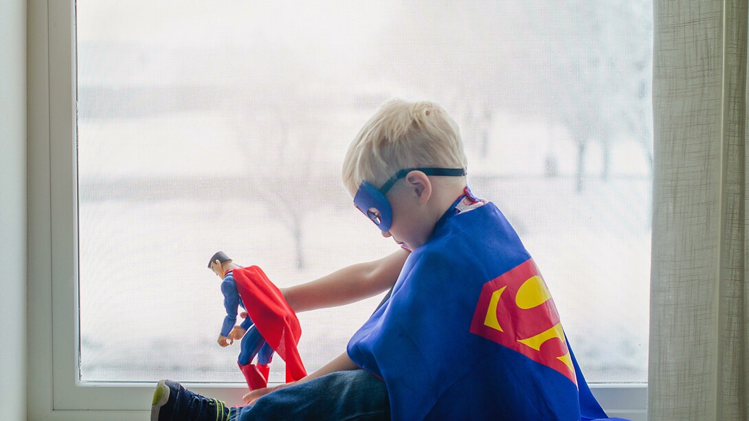 Menino fantasiado brinca de super-homem