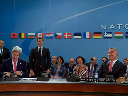 On May 19, 2016, at NATO Headquarters in Brussels, Belgium, U.S. Secretary of State John Kerry, watched by Montenegrin Prime Minister Milo Djukanovic, signed an Accession Protocol to advance Montenegro's admission to NATO during the biannual Foreign Ministerial Meetings