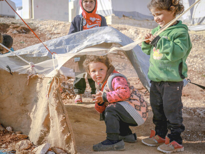Niños inmigrantes juegan con los escombros del campo de refugiados