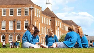 Jóvenes de uniforme en el jardín de un colegio privado